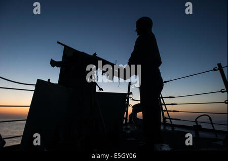 U.S. Navy Yeoman 3rd Class Megan Ludwig mans a .50-caliber machine gun aboard the guided missile destroyer USS Truxtun (DDG 103 Stock Photo