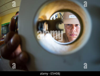 U.S. Navy Construction Electrician 2nd Class Arthur Bernal installs a doorknob while assisting with renovations at Bethel Seven Stock Photo