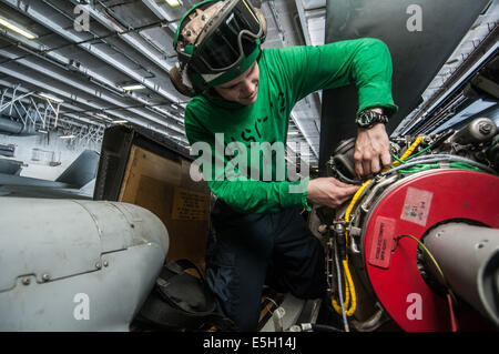 U.S. Navy Aviation Electrician's Mate Airman Spencer Tyo performs maintenance on an engine harness of an MH-60S Seahawk helicop Stock Photo
