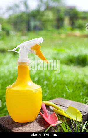 Gardening tools. Plastic watering can, mini shovel and fork on grass background Stock Photo