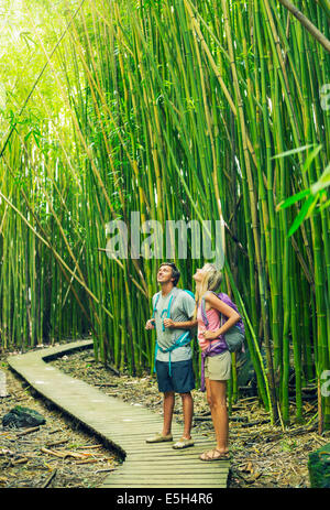 Couple having fun together outdoors on hike through amazing bamboo forest trail. Stock Photo