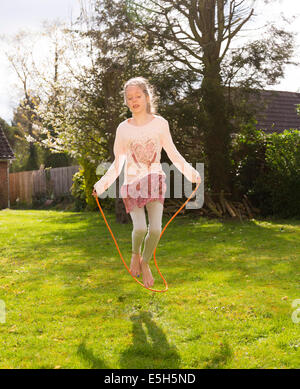 young girl using skipping rope Stock Photo