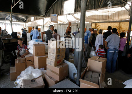 Palestinians receive their monthly food aid at a United Nations distribution center (UNRWA) in the Rafah refugee camp, Southern Gaza Strip. Palestinian President, Mahmoud Abbas declared the Gaza Strip as 'disaster area', as Israel pressed on with a military campaign against militants in the coastal territory. © Abed Rahim Khatib/Pacific Press/Alamy Live News Stock Photo