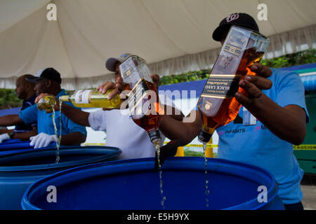 (140801) -- SANTO DOMINGO, Aug. 1, 2014 (Xinhua) -- Employees of the Customs General Direction (DGA, for its acronym in Spanish), pour alcoholic beverages after being seized, in Santo Domingo, Dominican Republic, on July 31, 2013. The DGA destroyed on Thursday 2000 boxes of whisky and alcoholic beverages, seized when being entered by contraband on national territory. The 2000 boxes, equivalent to 16,723.13 liters of different types of alcoholic beverages, with an approximate value of 11,793,331.76 dominican pesos, informed the engineer Fernando Fernandez, head of the DGA. (Xinhua/Roberto Guzma Stock Photo