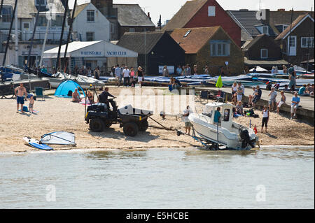 Inshore pleasure boat being launched on the beach during oyster festival at Whitstable Kent England UK Stock Photo