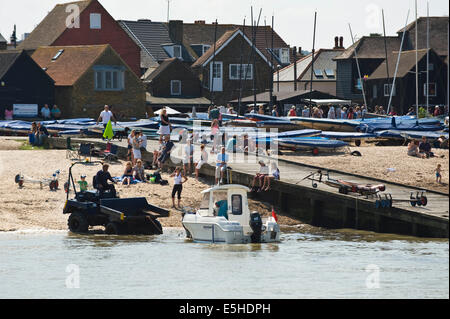 Inshore pleasure boat being launched on the beach during oyster festival at Whitstable Kent England UK Stock Photo