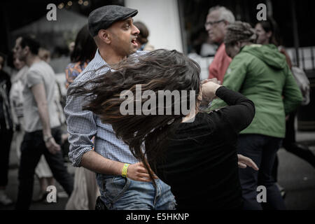 Action from two dancers doing a samba in public at Marylebone Street Fayre fair street party, London, UK. Stock Photo