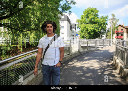 portrait of young male student with a headphones in the town Stock Photo