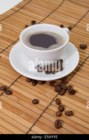 Kaffee mit Kaffeebohnen auf Bambus Stock Photo