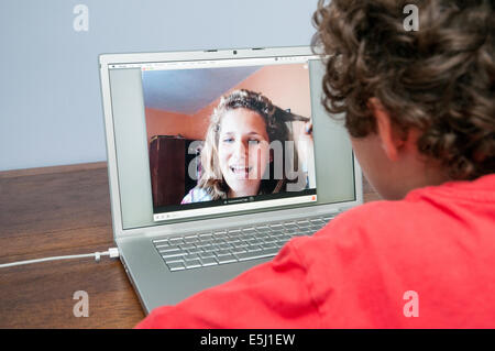 Teenager talking on Skype on Apple laptop computer, England, UK Stock Photo