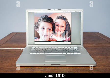 Children talking on Skype on Apple laptop computer, England, UK Stock Photo