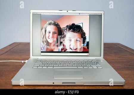 Children talking on Skype on Apple laptop computer, England, UK Stock Photo