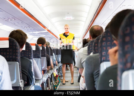 EasyJet cabin crew demonstrating use of lifejacket during safety procedure Stock Photo