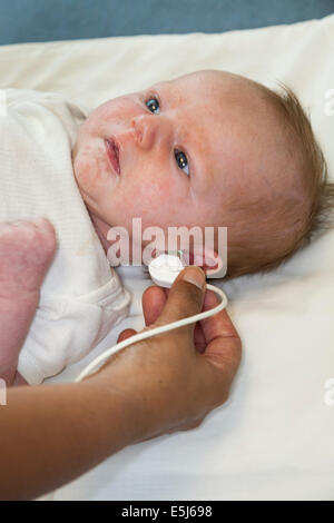 Newborn / new born baby undergoes a neonatal hearing screening test: Automated otoacoustic emissions test. Stock Photo