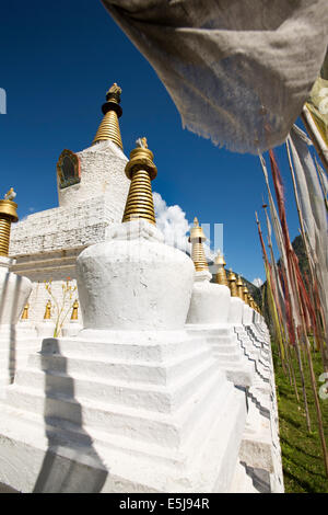 Eastern Bhutan, Lhuentse Valley Autsho, white Tibetan style brick built chorten surrounded by prayer flags Stock Photo