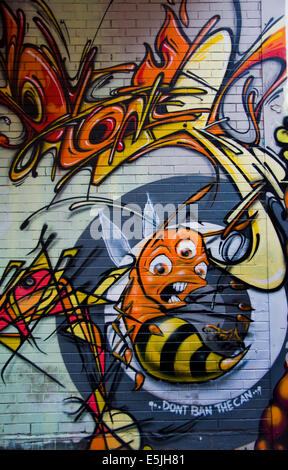 Colorful graffiti in back alley of downtown, depicts a bunch of scary looking bee. Stock Photo