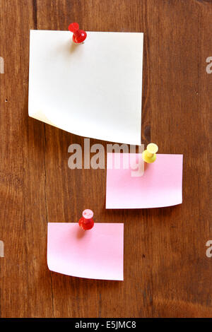 Three blank note papers attached to a wooden wall Stock Photo