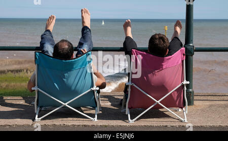 Sidmouth , Devon, UK. 2nd Aug 2014. Relaxing on the seafront during the Sidmouth 60th Folk Festival till 8th August. Credit:  dPAD/Alamy Live News Stock Photo