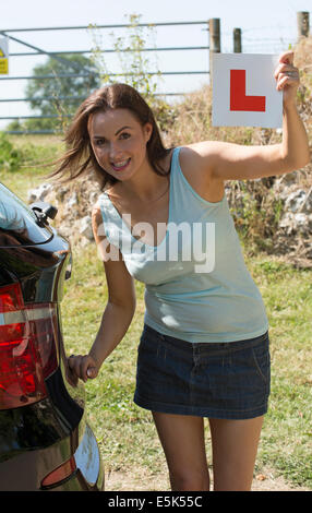 Female motorist holding learner L plate Stock Photo