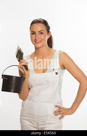 Painter wearing bib & braces overall holding brush Stock Photo