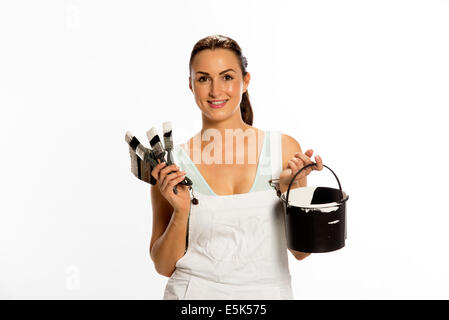 Painter wearing bib & braces overall holding brush Stock Photo