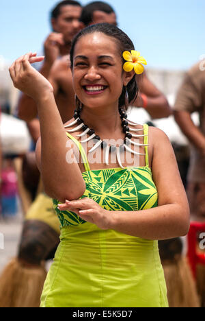A Polynesian female dancer performing in costume at a cultural show