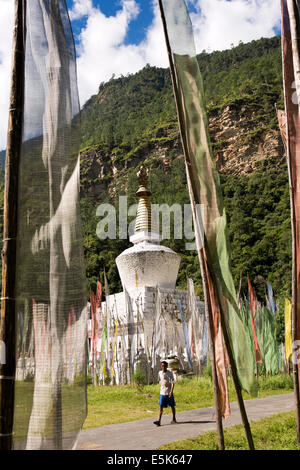 Eastern Bhutan, Lhuentse Valley Autsho, man walking past white Tibetan style brick built chorten Stock Photo