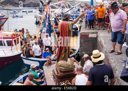 San Juan, Tenerife, Canary Islands, Spain. 03rd Aug, 2014. The Nuestra senora del Carmen and San Juan Bautista effigies are taken to the harbour and loaded on to fishing boats for a maritime procession accompanied by an armada of boats to visit neighboring fishing villages as part of the annual fiesta in Playa San Juan, tenerife, canary Islands, Spain. Credit:  Phil Crean A/Alamy Live News Stock Photo