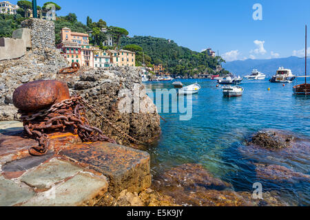 Old rusty bollard with marine chain on remains of old port in Portofino, Italy. Stock Photo