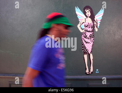 London, UK. 03rd Aug, 2014. London graffiti artist Pegasus has painted a new piece of the late singer Amy Winehouse. The work, which shows her wearing Union Jack angel's wings, has appeared on the side of antiques shop Paul's Emporium in North London not far from the singer's former home in Camden Town. American-born Pegasus has painted several portraits of her but says this new piece is his 'final farewell' to the singer who died just over three years ago. Credit:  Jeffrey Blackler/Alamy Live News Stock Photo