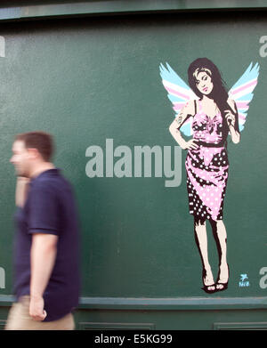 London, UK. 03rd Aug, 2014. London graffiti artist Pegasus has painted a new piece of the late singer Amy Winehouse. The work, which shows her wearing Union Jack angel's wings, has appeared on the side of antiques shop Paul's Emporium in North London not far from the singer's former home in Camden Town. American-born Pegasus has painted several portraits of her but says this new piece is his 'final farewell' to the singer who died just over three years ago. Credit:  Jeffrey Blackler/Alamy Live News Stock Photo