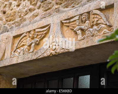 Detail of Angels above a Doorway. Angels carved into the lintel stone above a house doorway in Pals. Stock Photo