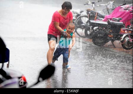 Taiyuan, China's Shanxi Province. 4th Aug, 2014. Citizens walk in rain in Taiyuan, capital of north China's Shanxi Province, Aug. 4, 2014. Heavy rainfall hit the city on Monday. Credit:  Fan Minda/Xinhua/Alamy Live News Stock Photo