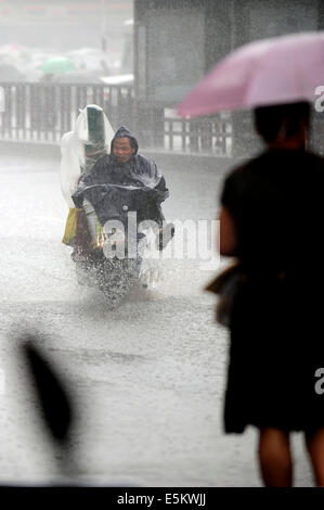 Taiyuan, China's Shanxi Province. 4th Aug, 2014. A citizen rides a motorcycle on a waterlogged road in Taiyuan, capital of north China's Shanxi Province, Aug. 4, 2014. Heavy rainfall hit the city on Monday. Credit:  Fan Minda/Xinhua/Alamy Live News Stock Photo