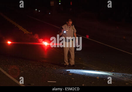 Aug. 3, 2014 - Modesto, CA, USA - A fatal vehicle vs semi truck trailer accident killed a driver in north west Modesto CA. Sunday Aug. 3rd 2014 night.  A CHP officer looks over evidence after a Mazda MPV driven by a 56yr old female slammed into the back of a Kharod Enterprises Inc. semi truck out of Fremont CA that was traveling east up the Beckwith Rd over crossing about 9:30pm killing the driver of the Mazda MPV on impact. The California Highway Patrol is investigating the accident. (Credit Image: © Marty Bicek/ZUMA Wire) Stock Photo