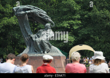 A piano concert taking place at the Statue of Frederic Chopin in Lazienki Park in Warsaw, Poland. Stock Photo