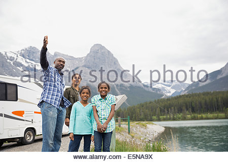 Portrait of family at lakeside below mountains