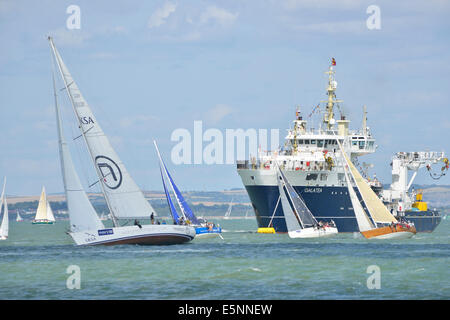 Yachts race in front of THV Galatea  moored of Cowes .Trinity House’s Multi Functional Tender (MFT), GALATEA,is Prince Philip's   base while attending the opening few days of Aberdeen Asset Management Cowes Week Regatta, Cowes, Isle of Wight, UK Stock Photo