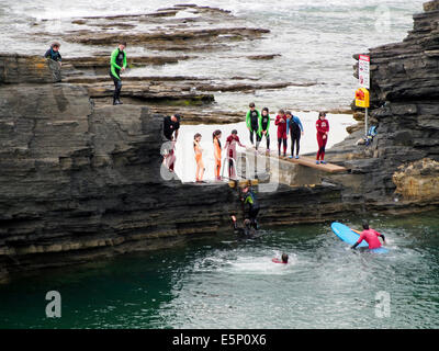 Young people diving from rocks at Bundoran, County Donegal, Ireland as part of a youth adventure holiday. Stock Photo