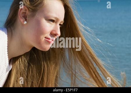 Pretty blond teenage girl at shore. Stock Photo