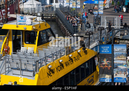 Water Taxi at New Yorks South Street Seaport. The historic district of South Street Seaport juxtaposed against the imposing Fina Stock Photo
