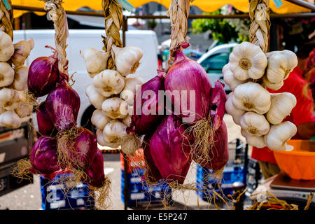 Garlic and red onions for sale in the market at Saint-Hilaire-du-Harcouet, Normandy, France Stock Photo