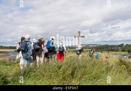 Group of walkers approaching Cuthbert's Cross on Church Hill, Alnmouth, Northumberland, north east England, UK Stock Photo