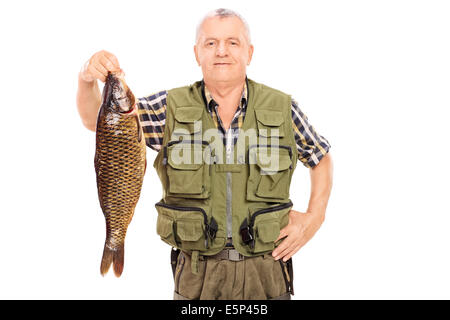 Happy mature fisherman holding a carp fish and gesturing good