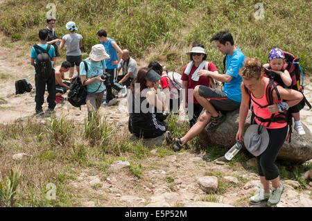Hikers take a break from their journey to the top of Sunset Peak on Lantau Island Hong Kong, China. Stock Photo