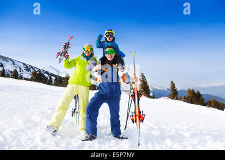 Mom, dad with child on his shoulders in ski masks Stock Photo