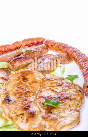 broil meat on plate with grilled chicken steak and sausages isolated on white background; various barbecue meat; hot meat dish Stock Photo
