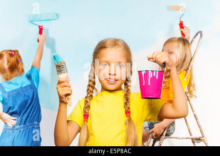 Girl and her friends painting wall Stock Photo