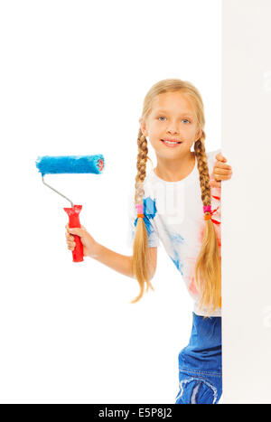 Girl with wool roller stands behind the corner Stock Photo