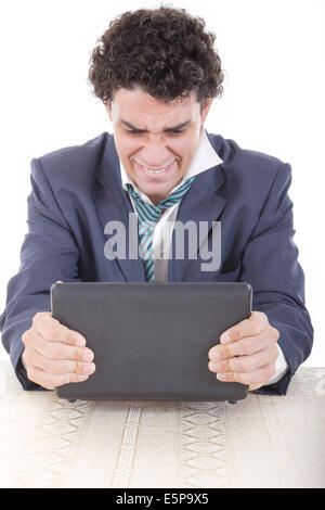 Photo of an angry caucasian business male frustrated with work sitting in front of laptop with his hands trying to break laptop Stock Photo
